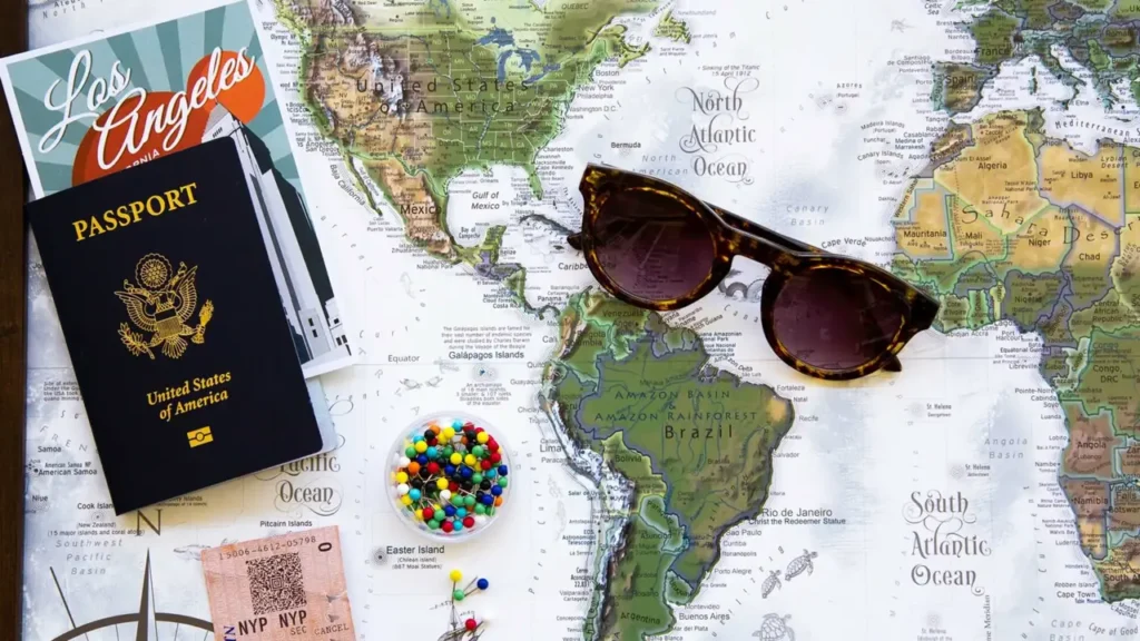 A US passport, sunglasses and pins laid out on a world map