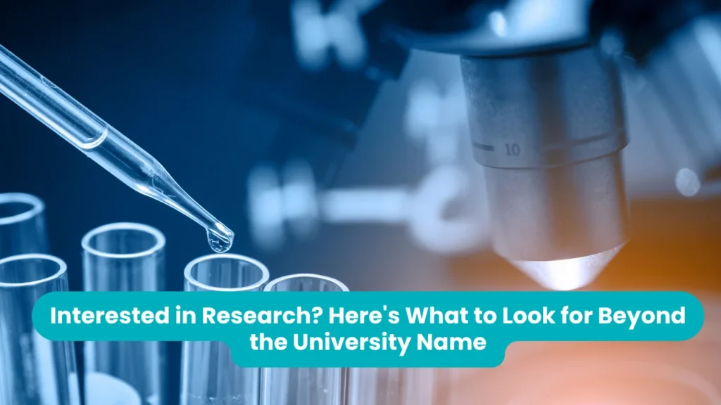 Banner reading 'Interested in Research? Here's What to Look for Beyond the University Name' across a blue-toned laboratory photograph of a glass pipette releasing a droplet into a row of test tubes, with an illuminated microscope objective lens behind them