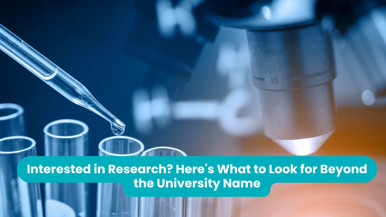 Banner reading 'Interested in Research? Here's What to Look for Beyond the University Name' across a blue-toned laboratory photograph of a glass pipette releasing a droplet into a row of test tubes, with an illuminated microscope objective lens behind them