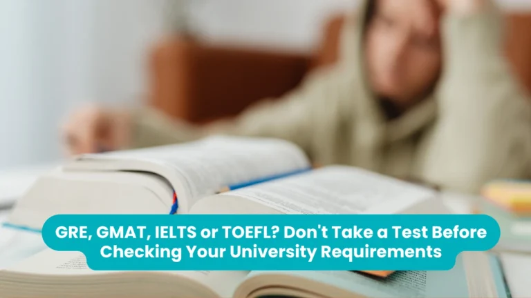 Banner reading 'GRE, GMAT, IELTS or TOEFL? Don't Take a Test Before Checking Your University Requirements' across a photograph of open textbooks on a desk with a student resting their head on one hand in the blurred background