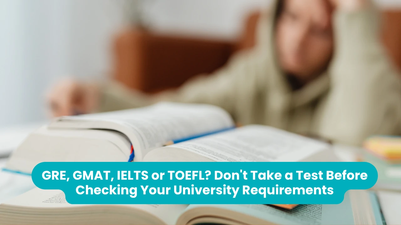Banner reading 'GRE, GMAT, IELTS or TOEFL? Don't Take a Test Before Checking Your University Requirements' across a photograph of open textbooks on a desk with a student resting their head on one hand in the blurred background
