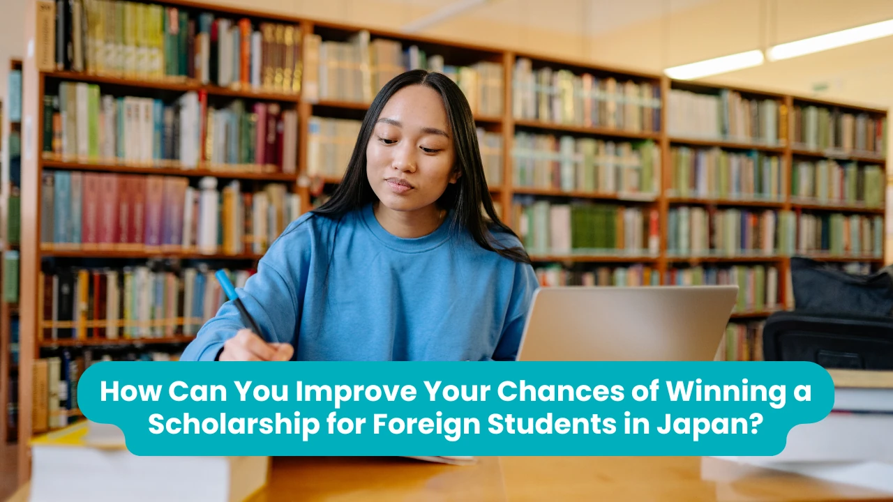 How Can You Improve Your Chances of Winning a Scholarship for Foreign Students in Japan? — a student in a blue sweatshirt writing at a library desk beside an open laptop, tall shelves of books behind her