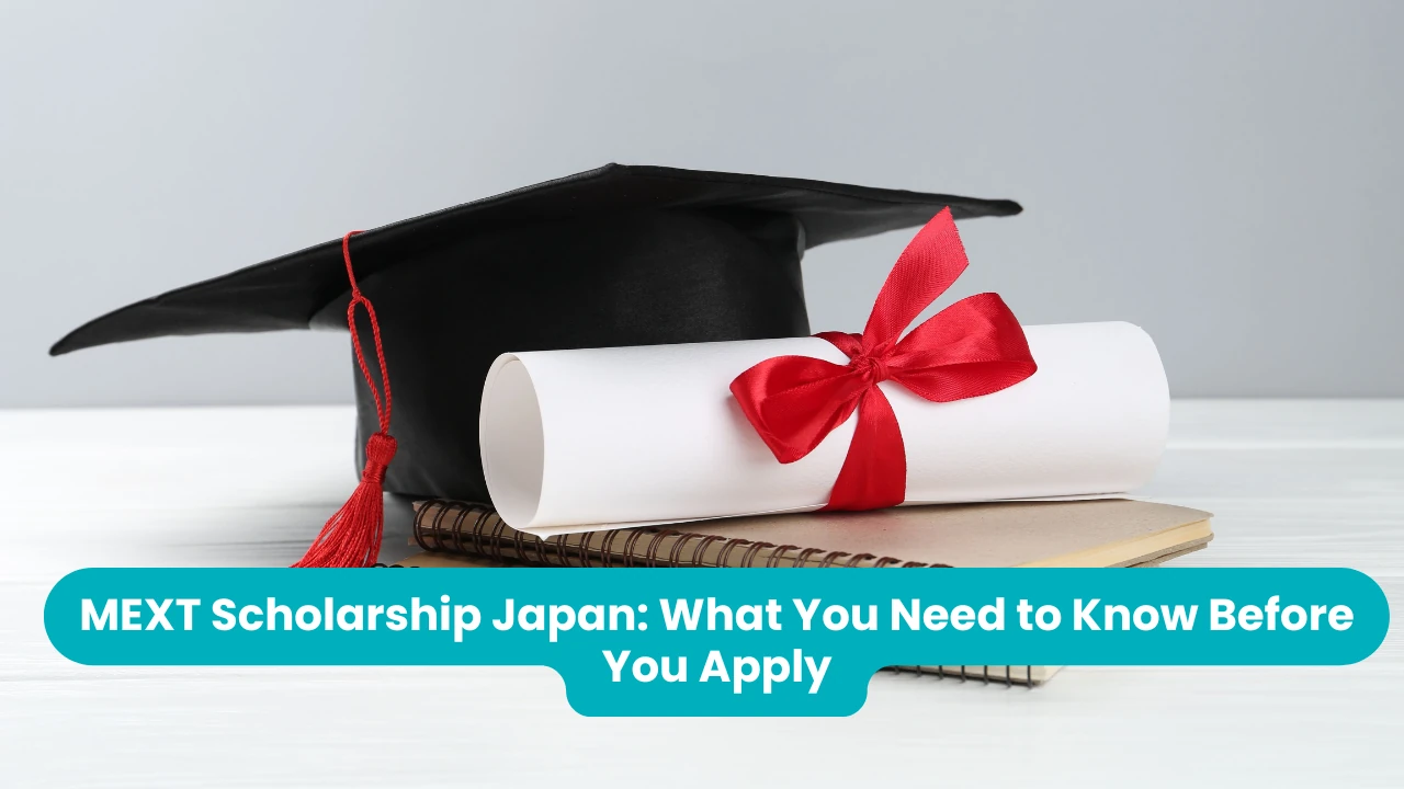 MEXT Scholarship Japan: What You Need to Know Before You Apply — a black mortarboard with a red tassel beside a rolled diploma tied with a red ribbon, resting on spiral notebooks
