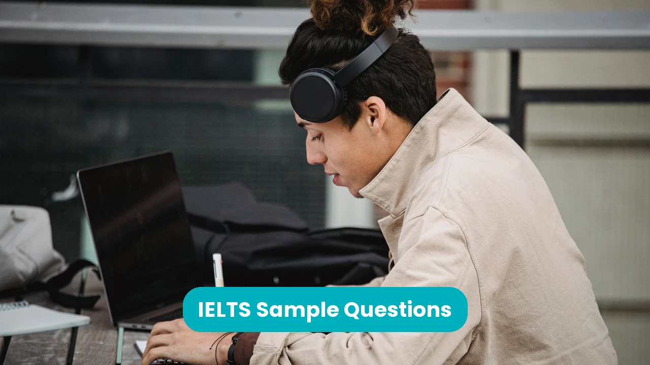 Banner reading 'IELTS Sample Questions' across a photograph of a young man in headphones studying at a laptop at an outdoor table, writing in a notebook